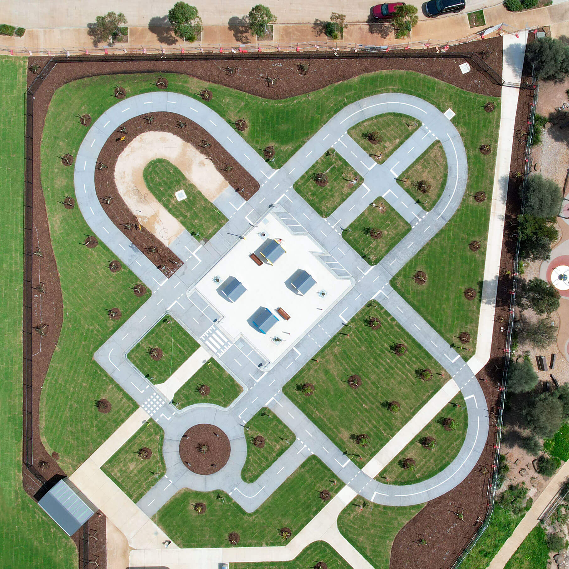 An aerial view of a bike and scooter park with small roads, intersections, and a central play area.